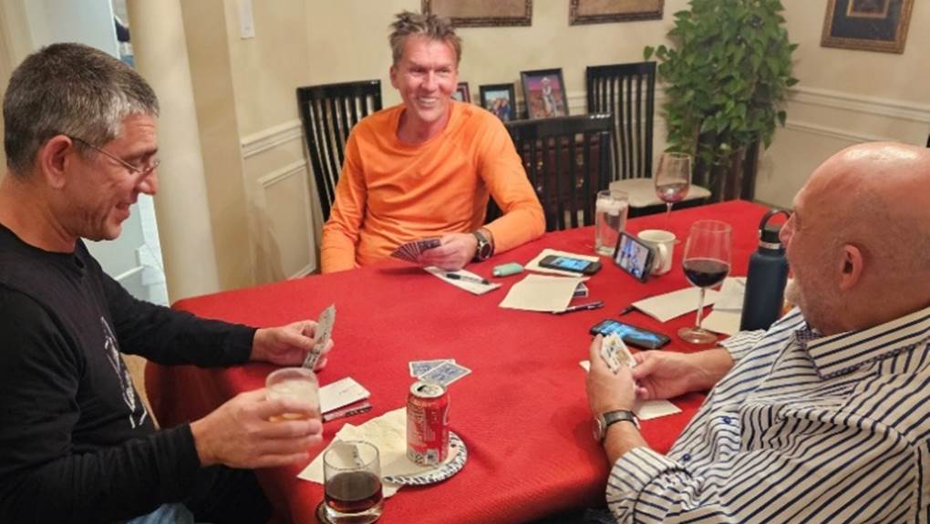 A group of men playing cards

Description automatically generated