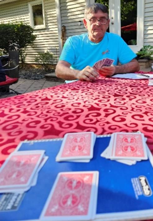 A person playing cards on a table

Description automatically generated