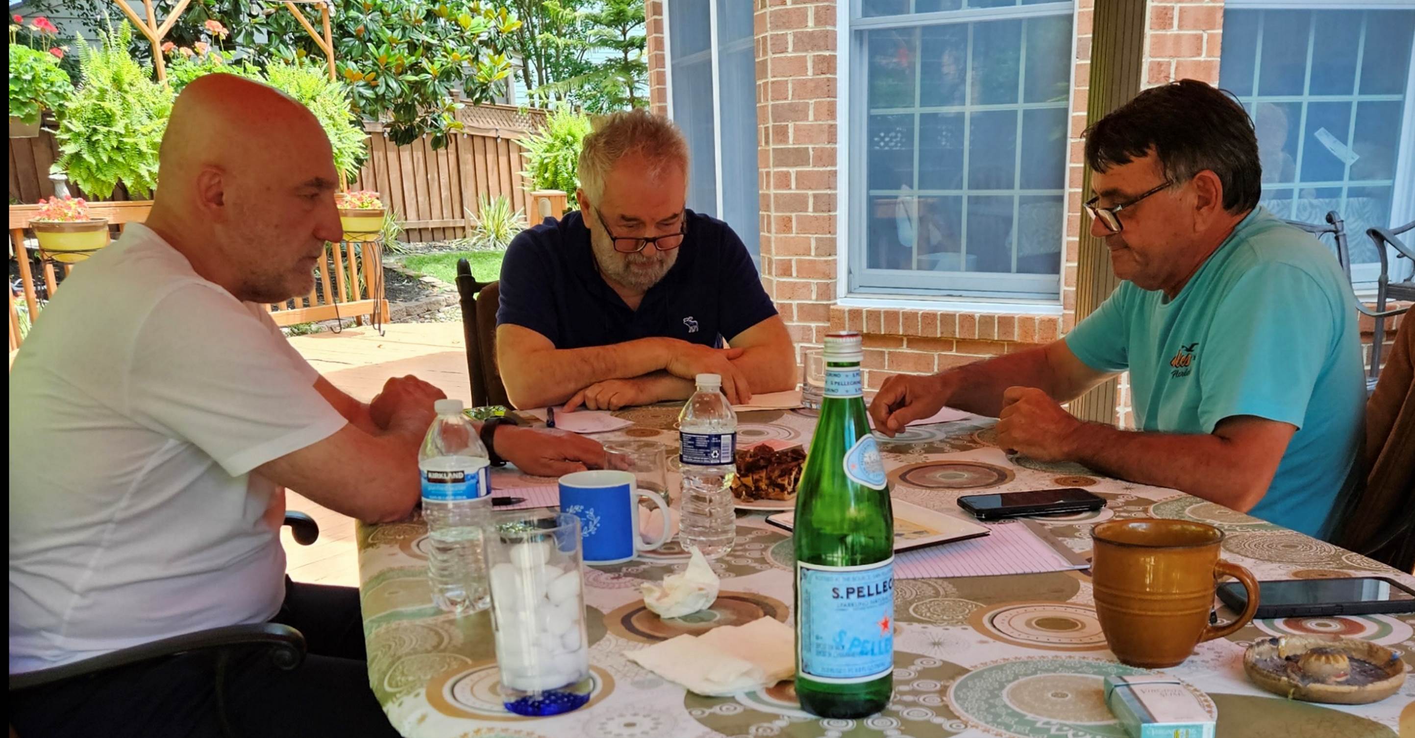 A group of men sitting at a table

Description automatically generated