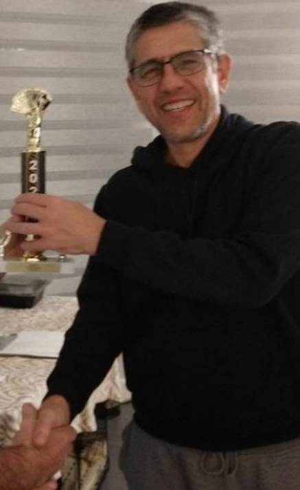 A person holding a trophy

Description automatically generated with medium confidence